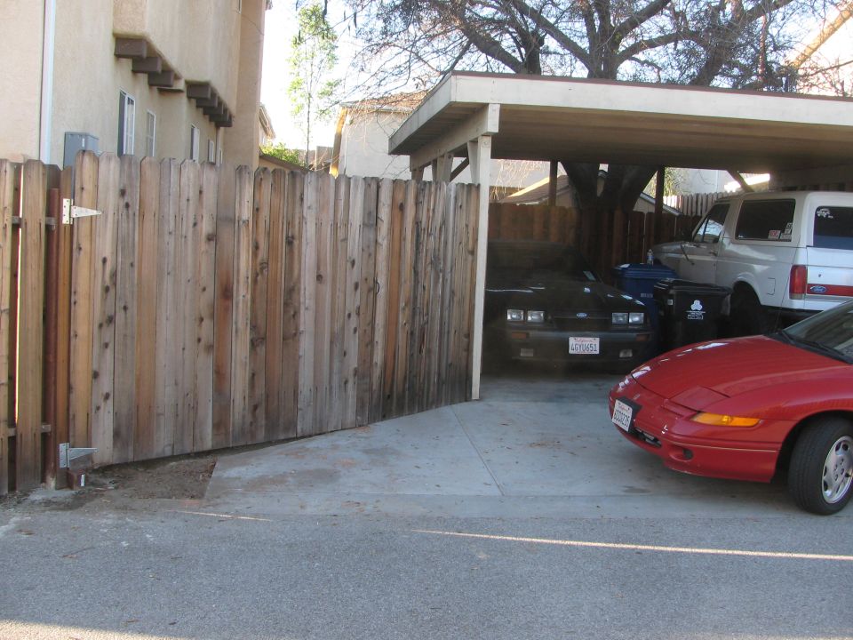 Black coupe with license plate 6GYD51 parked under a carport