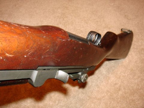 2003 Ford Crown Victoria - Detail of an M1 Garand rifle receiver and stock, showing the metal parts and wood grain.
