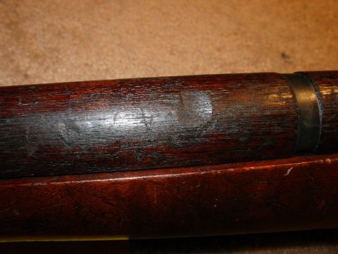 2003 Ford Crown Victoria - Detail of a wooden firearm stock showing wear and a metal band.
