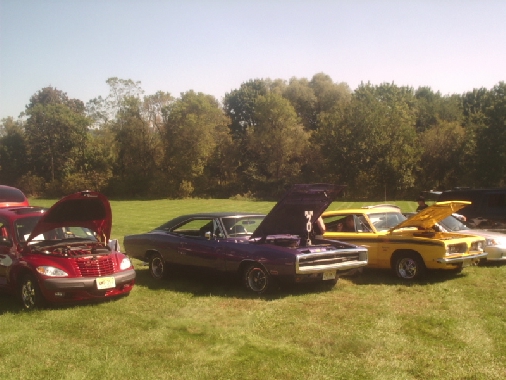 Purple 1970 Dodge Charger with hood open, parked on grass
