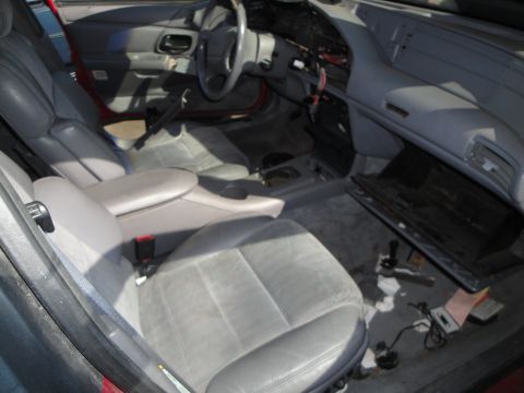 1993 Ford Taurus - The interior of a 1993 Ford Taurus is visible, gray cloth seats and a dashboard with some parts removed.
