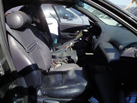 1993 Ford Taurus - Interior of a 1993 Ford Taurus with exposed wiring and seats visible; another car is seen through the window.