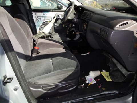 1993 Ford Taurus - The interior of a 1993 Ford Taurus, the front seats and dashboard, appears to be in a junkyard.