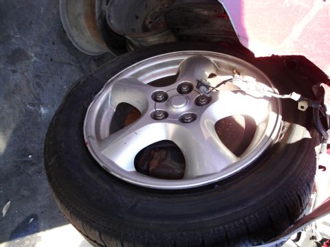 1993 Ford Taurus - Close-up of a silver 5-spoke wheel and tire, with visible wiring near the hub.