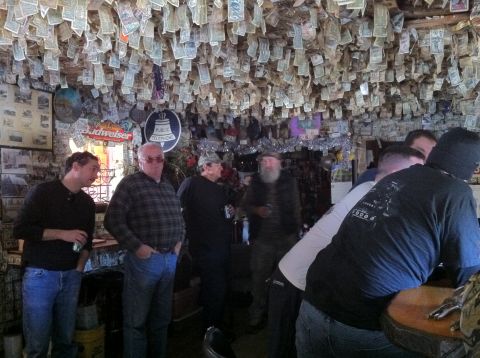 1989 Ford Bronco - A bar interior is decorated with numerous bills hanging from the ceiling and walls.