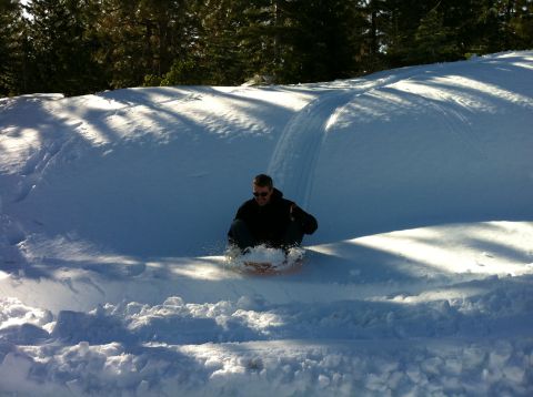 1989 Ford Bronco - A man enjoys a winter day sledding down a snow-covered slope.