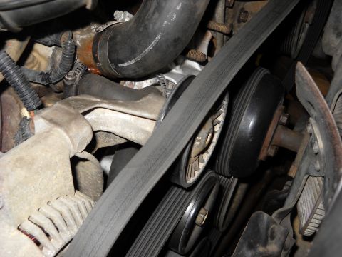 1993 Ford C-150 (Centurion Conversions) - Close-up view of an engine's belt and pulley system.