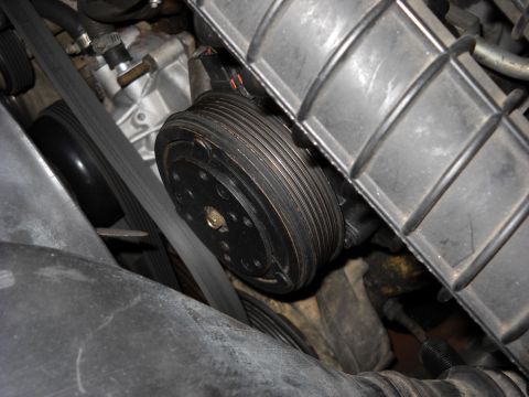 1993 Ford C-150 (Centurion Conversions) - Engine compartment detail showing belts and pulleys, possibly an AC compressor clutch.