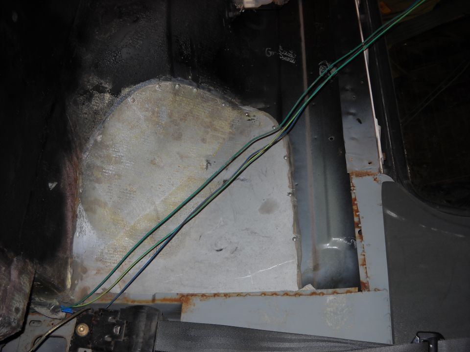 Interior view of metal paneling, wiring, and seatbelt