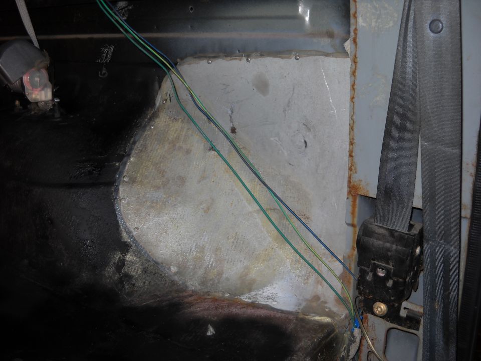 Interior view of wiring and seatbelt mechanism in a vehicle
