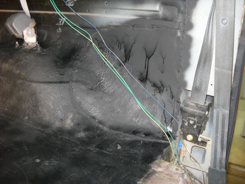1993 Ford C-150 (Centurion Conversions) - The interior of a vehicle shows exposed wiring and sound deadening material on the floor and rear wall.