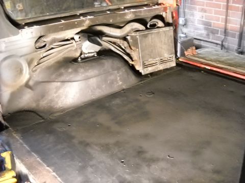 1993 Ford C-150 (Centurion Conversions) - The interior of a vehicle shows exposed wiring and a metal enclosure mounted on the rear wall.