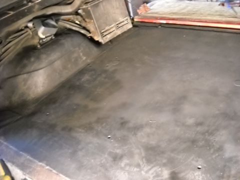 1993 Ford C-150 (Centurion Conversions) - The bare interior floor of a vehicle shows wiring and a metal component under the dash.