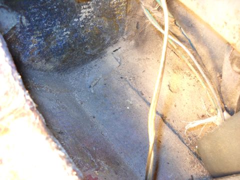 1993 Ford C-150 (Centurion Conversions) - Close-up view of the interior floor pan, showing wiring and signs of rust.