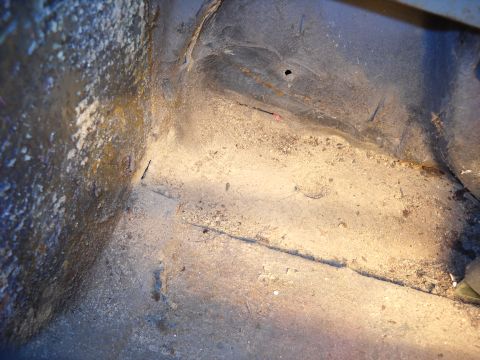 1993 Ford C-150 (Centurion Conversions) - The underside of a vehicle's interior shows a worn and corroded floor pan.