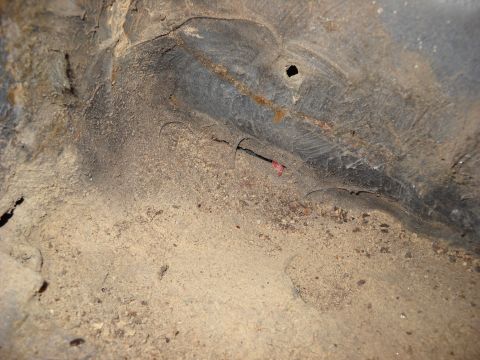 1993 Ford C-150 (Centurion Conversions) - Close-up view of the dirty and rusted undercarriage of a vehicle, showing a wire with red tape.