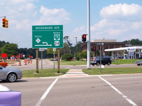 1971 Ford Ranchero - A street scene captures an intersection with directional signage and a gas station, with several vehicles present.