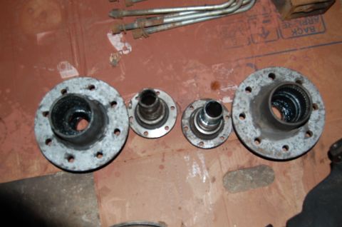1994 Ford Bronco - Several vehicle hub assemblies and metal rods are laid out on a surface.