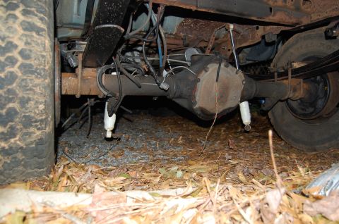1994 Ford Bronco - Close-up view of the rear axle and suspension system, showing dual shock absorbers and leaf springs.