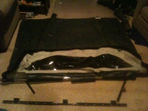 1993 Ford Bronco - A disassembled vehicle soft top is shown laid out on a carpeted floor.