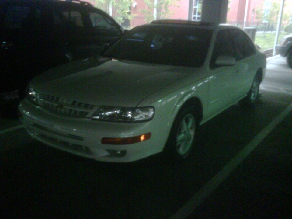 White 1999 Nissan Maxima sedan parked, front 3/4 view, sunroof visible