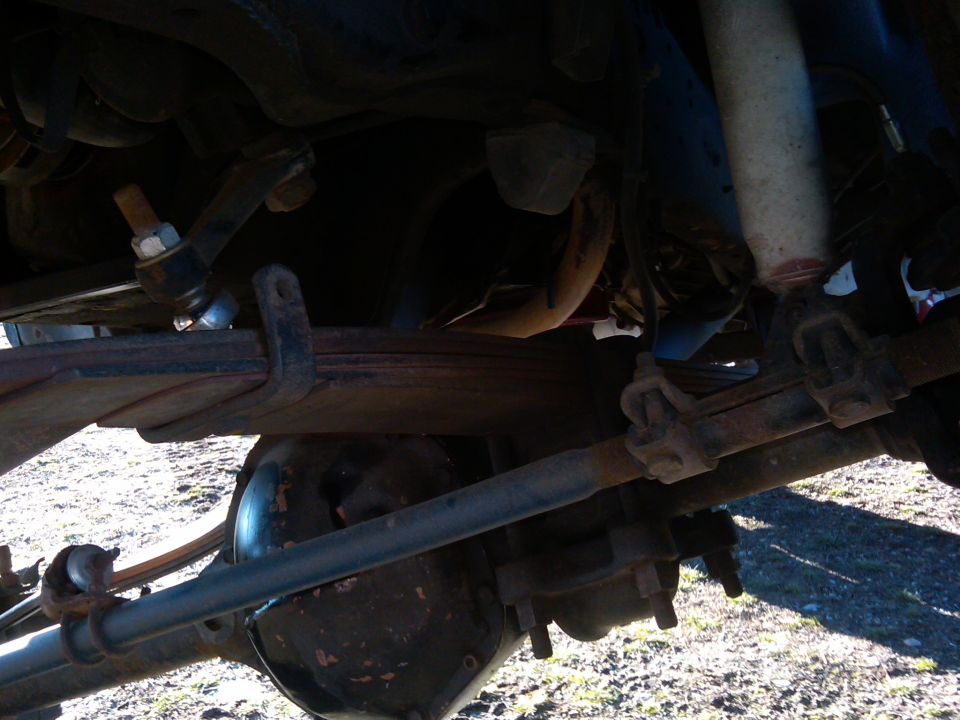 Undercarriage view showing leaf springs, shock absorber, and differential housing