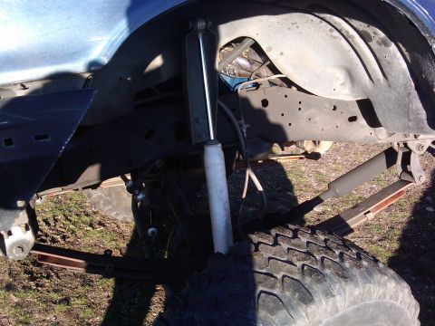 1988 Ford Bronco - The vehicle's suspension system, large tires and heavy-duty shocks, is visible in this close-up shot.