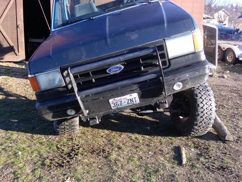 1988 Ford Bronco - This 1988 Ford Bronco is shown with its front passenger wheel elevated on a log, demonstrating its off-road capabilities.