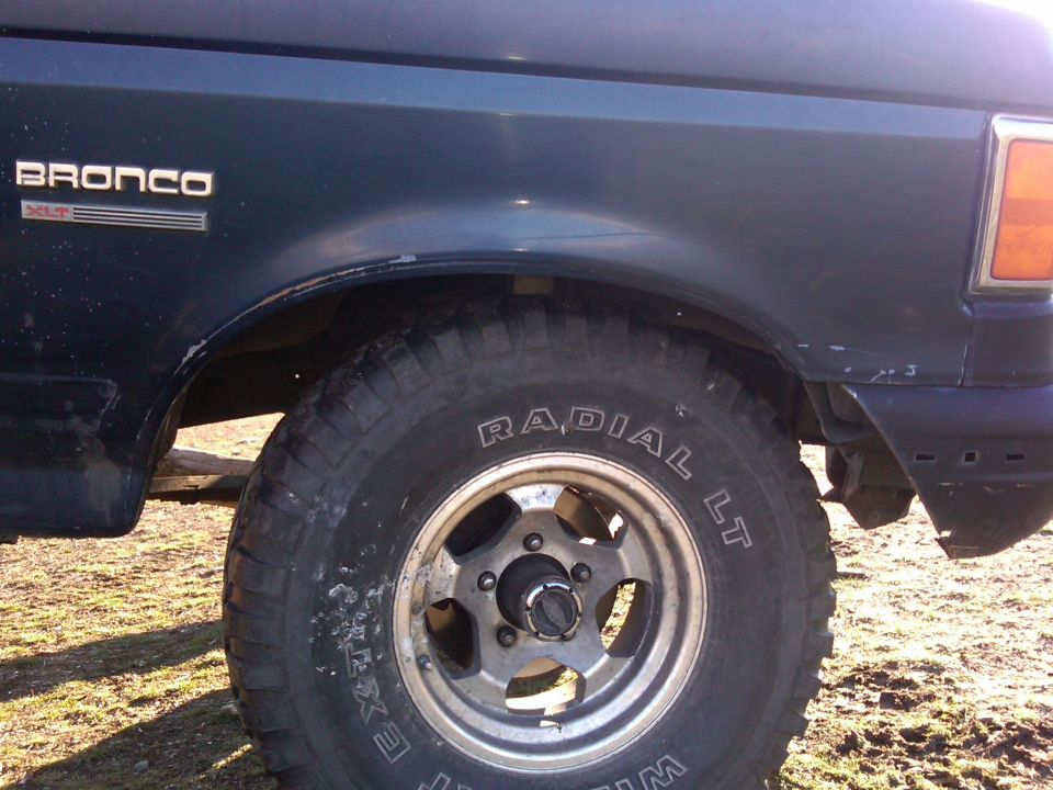 1988 Ford Bronco XLT fender, wheel, and tire. "BRONCO XLT" badge visible
