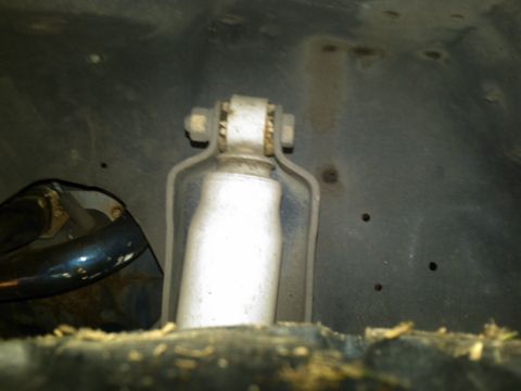 1988 Ford Bronco - This image shows the suspension system of a vehicle, focusing on the shock absorber and its attachment points.