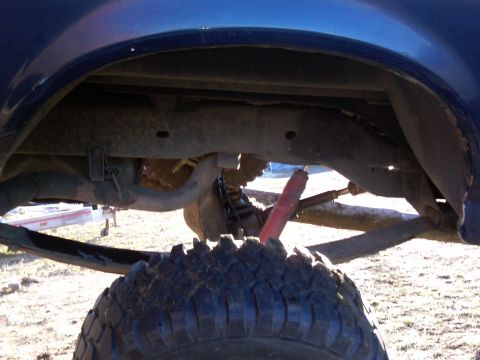 1988 Ford Bronco - Close-up of the rear suspension and axle of a blue 1988 Ford Bronco.