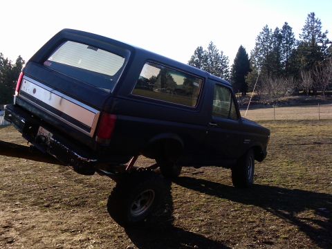 1988 Ford Bronco - This 1988 Ford Bronco is shown at an angle, highlighting its dark blue paint and silver rear stripe.