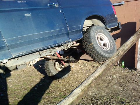 1988 Ford Bronco - This blue 1988 Ford Bronco is shown navigating an off-road obstacle.