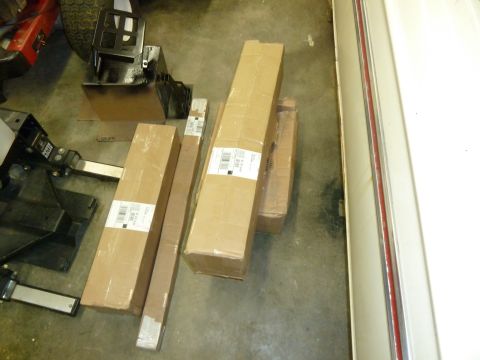 1992 Ford Mustang - Cardboard boxes are stacked on a garage floor next to the side of a vehicle with red trim.