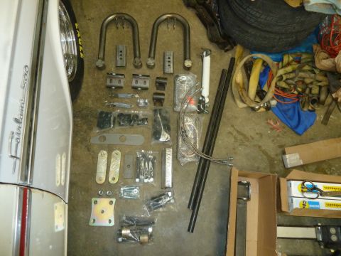 1992 Ford Mustang - Various automotive parts are laid out on the floor next to a car fender.