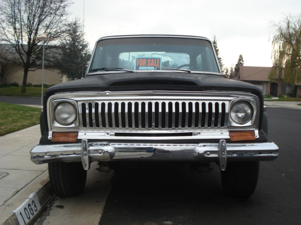 1977 Jeep Cherokee front view with chrome grille and 'For Sale' sign