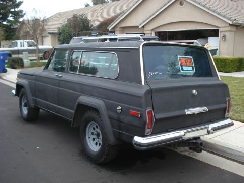 1977 Jeep Cherokee - 1977 Jeep Cherokee with 'FOR SALE' sign in the rear window, parked on a residential street.