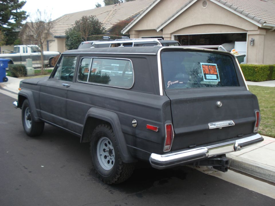 1977 Jeep Cherokee parked on street, rear view. Has 'FOR SALE' sign in window