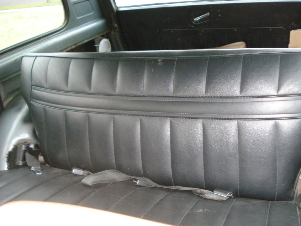 Black vinyl rear seat with seatbelts in a vehicle interior