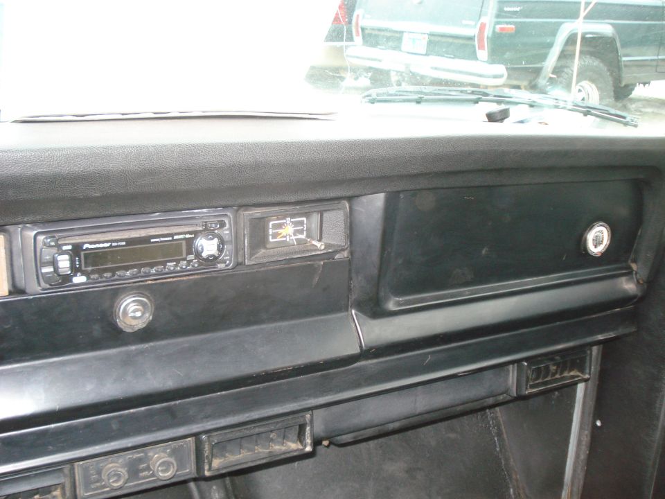 Interior dashboard of a 1977 Jeep Cherokee with Pioneer stereo and clock