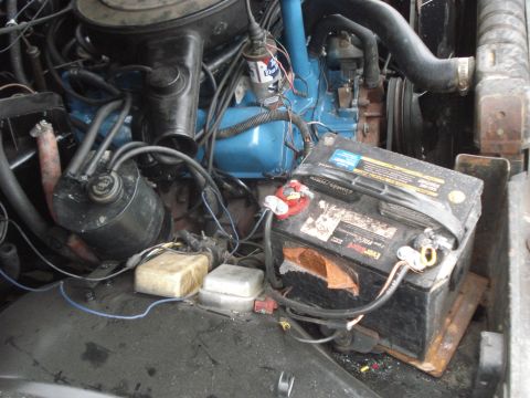 1977 Jeep Cherokee - Close-up view of a vehicle's engine bay, focusing on the battery and engine components.