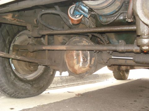 1977 Jeep Cherokee - Close-up of the undercarriage, focusing on the drivetrain and suspension components of an older vehicle.