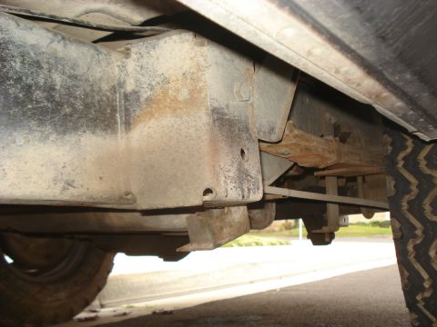 1977 Jeep Cherokee - A close-up view of a vehicle's undercarriage reveals signs of wear and rust on its suspension components.