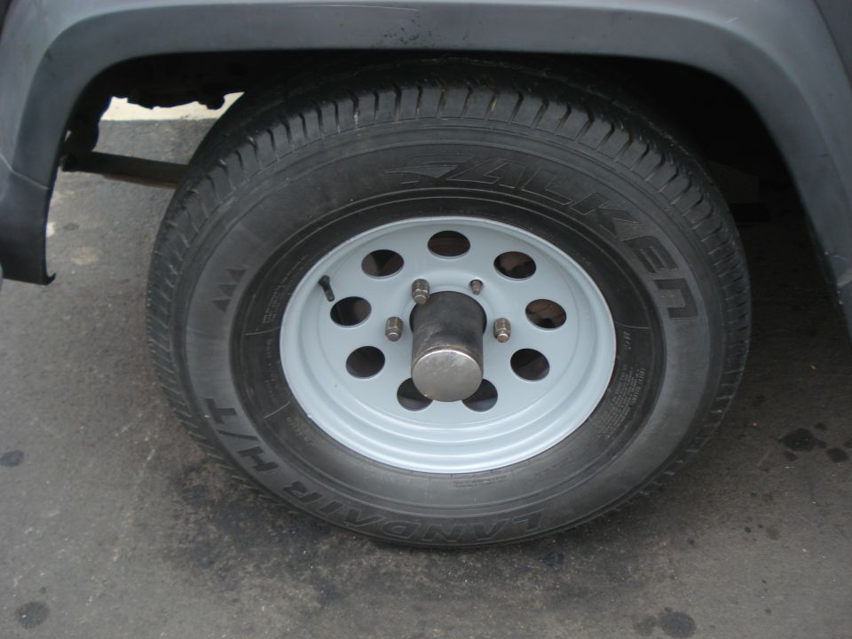White steel wheel with Falken Landair H/T tire and bare metal hub cap
