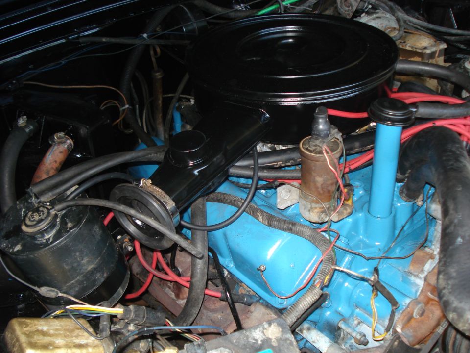 Engine bay with blue valve covers, black air cleaner, and various hoses and wires