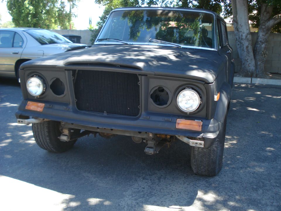 Black 1977 Jeep Cherokee front end with missing headlights