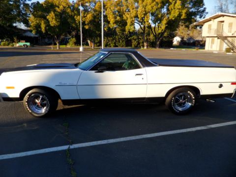1973 Ford Ranchero - A white 1973 Ford Ranchero is parked in a lot, showing its side profile and black accents.