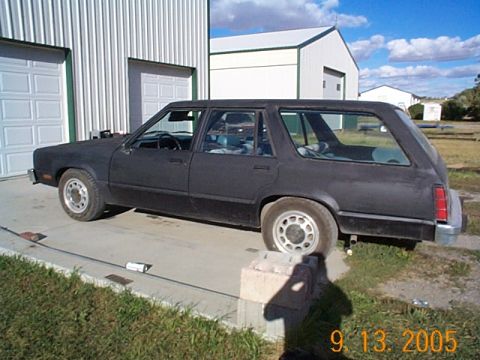 1982 Mercury Zephyr - A dark-colored station wagon is parked outside a garage with a cloudy sky overhead.