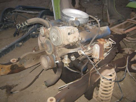 1972 Ford F-250 - Disassembled engine and chassis parts are laid out, showing a V8 engine and rusty frame components.