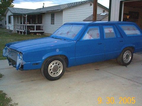 1982 Mercury Zephyr - A blue station wagon sits in a driveway with its windows taped off, suggesting it's being prepped for painting.